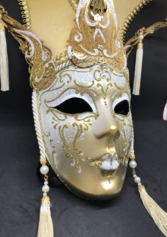 Venetian Mask for decoration - Traditional and original papier-mache Venetian mask, handmade and decorated with metal insert, gold-leaf and glitters,enriched with Swarovski crystals. dimensions::Hight 43cm,width 27cm Decorations only,Not wereable All our masks are handmade papier-machè masks made in Venice. Our decorators use techniques typical of the Venetian tradition such as stucco, acrylics, gold and silver-leaf, macramè, passementerie, glitters and crequelè to offer you a wide range of orig Gold Venetian Mask For Halloween, Venetian Gold Masquerade Mask For Halloween, Venetian Full Face Halloween Mask, Gold Venetian Masquerade Mask For Halloween, Venetian Full Face Mask For Halloween, Venetian Masks For Themed Carnival Events, Full Face Venetian Halloween Mask, Fantasy Full Face Mask For Carnival, Venetian Masks And Prosthetics For Carnival