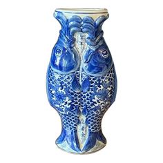 a blue and white vase with two fish on it's face, sitting in front of a white background