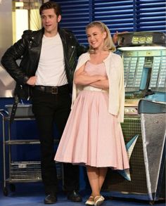 a man and woman standing next to each other in front of a vending machine