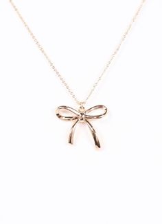 This delicate necklace has a shiny metal bow charm. Great for dainty accessorizing or layering with other necklaces. Dimensions: 15.5" 3" extender Chic Metal Jewelry With Bow Detail, Gold Bow Necklace For Party, Gold Necklace With Bow For Party, Gold Necklace With Decorative Bow For Party, Elegant Gold Necklace With Decorative Bow, Delicate Bow Necklace For Party, Feminine Bow Necklace For Party, Chic Bow Necklace For Gift, Delicate Charm Necklace With Adjustable Chain For Party