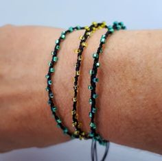 a woman's arm with three bracelets on it