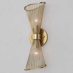 a gold wall light with two lights on it's side and a wire basket hanging from the back