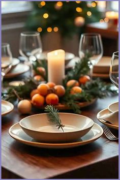 Festive table setting with a centerpiece of oranges, greenery, and a lit candle. Compost Bucket