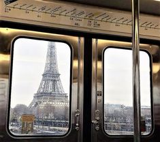 the eiffel tower is reflected in the windows of a subway car that has its doors open