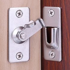 a close up of a door handle on a wooden door with metal latch and bolt