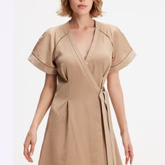 A minimalist and chic cut, this dress elegantly emphasizes any type of silhouette: fitted to the waist not a wallet system, wide raglan cuffs, V neckline and flared volume. Refined finishes with inlaid openwork braid and satin trim at the sleeves and along the neckline. A timeless cut in a soft poplin-type fabric that is easy to iron. This dress adapts to various occasions and will be a chic and safe option for your evenings or for the office. Main fabric:  100% Polyester Finishes: 65% Viscose, Modern V-neck Spring Dresses, Elegant Short Sleeve V-neck Dress For Brunch, Structured A-line Summer Dress, Modern V-neck Mini Dress For Spring, Modern V-neck Dress For Work, Elegant Fitted V-neck Dress For Daywear, Modern V-neck Dresses For Daywear, Elegant V-neck Belted Mini Dress, Chic A-line V-neck Dress For Brunch