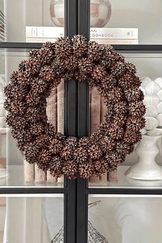 a wreath is hanging on the glass front door to show it's natural beauty