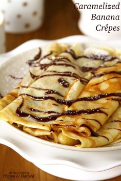 crepes with caramelized and chocolate drizzled on them in a white dish