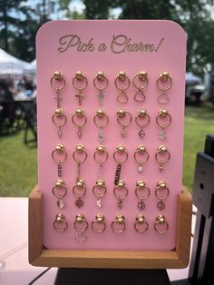 This unique display combines functionality with a chic aesthetic, making it the perfect addition to your permanent jewelry setup! Dimensions (without any base): 30 CHARM DISPLAY = approx. 6" x 8" 50 CHARM DISPLAY = approx. 8" x 8" 100 CHARM DISPLAY = approx. 10" x 11.75" --- PLEASE NOTE: Wooden stands are NOT offered with 100 charm displays! ---- Now featuring a sturdy wooden base and adorned with strategically placed rivets, adding an edgy yet refined flair. The rivets not only serve as eye-cat Permanent Jewelry Chain Display, Charm Display Ideas, Charm Bar Display, Tshirt Vendor Booth Display Ideas, Permanent Jewelry Display, Jewelry Vendor Display, Charm Display, Jewelry Display Ideas, Creative Jewelry Displays