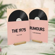 two pink records on wooden stand with flowers in the background and text that reads, the 1970's