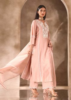 Achieve a sophisticated look with our embellished kurta and pants set. The kurta boasts intricate embellishments on the neckline and sleeves, while the pants feature embellishments on the hemline, adding an extra touch of elegance. Complete the ensemble with an embellished chanderi and organza dupatta. This set is perfect for special occasions where you want to make a lasting impression with your style and grace. Embellished Straight Kurta Sets For Eid, Festive Pant Set With Mirror Work And Straight Kurta, Elegant Pant Set With Chikankari Embroidery For Diwali, Elegant Unstitched Pant Set For Diwali, Pink Pant Set With Zari Work For Wedding, Festive Straight Kurta Pant Set With Mirror Work, Elegant Pant Set With Dabka Work For Diwali, Bollywood Style Pink Pant Set With Resham Embroidery, Pink Pant Set With Dupatta For Eid