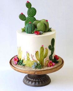 a cake decorated with cacti and succulents