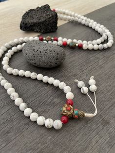 Beautiful Howlite Mala from Nepal and Mountain shell beads Mala necklace. You can choose between the mala that is made with howlite beads (white with gray) and mix metal beads from Nepal, or the all white mala necklace, which is made with mountain shell beads and a yellow mantra symbol. A unique praying mala that can be used as a necklace or as an ornament. The mala has no clasp, you wear it over the head. --The Mala with the metal beads and the red beads has a total length of 48.2cm- 19 inch lo White 108 Beads Jewelry As A Gift, Hand-strung White Round Bead Necklaces, White Hand-strung Round Bead Necklaces, Spiritual Colorful Beads Mala Gift, Colorful Round Beads Mala As A Gift, Spiritual Colorful Beads Mala As A Gift, White Beaded Bracelets With 108 Beads For Meditation, Colorful Round Beaded Mala As Gift, Adjustable White Mala With 8mm Beads