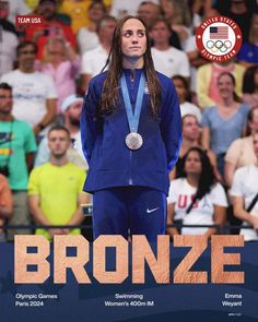 a woman standing on top of a tennis court with a medal around her neck and the words bronze in front of her