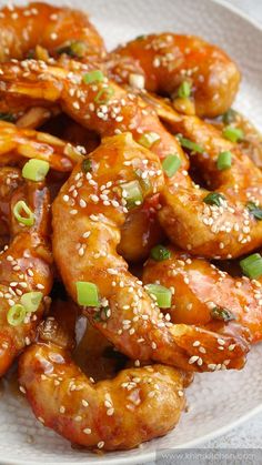 a white plate topped with shrimp covered in sesame seeds