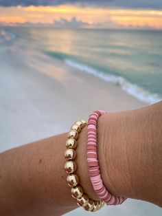 This is stack with a heishi bead bracelet and a fashion gold toned beaded bracelet. This is perfect for birthday gifts, party favors, bridal showers, weddings, baby showers, or even Christmas! You can select the size of these bracelets.  7 inches is the standard size for women and 8 inches for men This bracelet doesn't come with a clasp. If you want them with clasps, message me and I'll make a custom listing for you. It will cost extra to do a clasp.  If you need a larger quantity message me and we'll work something out.  If you have any problems purchasing anything from me message me and I'll try my best to make your purchase as smooth as possible.  Thank you, Chloe. Gold Heishi Beads Bracelets For Friendship, Gold Stackable Friendship Bracelets For Beach, Hand-strung Gold Stretch Bracelet For Beach, Gold Hand-strung Beach Stretch Bracelet, Pink Heishi Beads Bracelet With Gold Beads, Gold Stackable Stretch Bracelet For The Beach, Gold Stretch Bracelet With Round Beads For Beach, Gold Stretch Bracelet For Beach, Pink Bracelets With Gold Beads For Beach