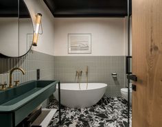 a bathroom with a bathtub, sink and mirror in it's center area