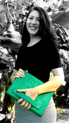 a woman holding a green purse in her hands