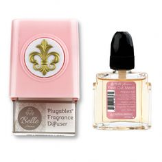 a bottle of cologne next to a pink and white box with a gold fleur de l'oeuvres on it