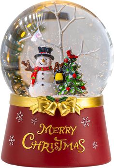 a snow globe with a snowman and christmas tree in it on a red base