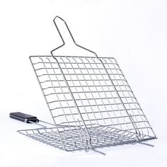 a frying pan with a spatula attached to it and a wire basket on the side