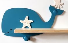 a blue whale shelf with an octopus and starfish on it's back, against a white wall