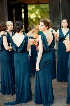 a group of women in long dresses standing next to each other on a brick floor