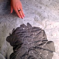 a woman's hand on top of a piece of fabric with stars and beads