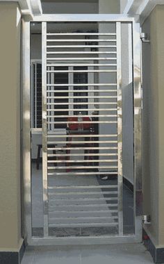 an open door with metal bars on the sides and side walk way to another room