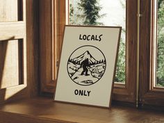 a sign that says locals only in front of a window with mountains and trees outside