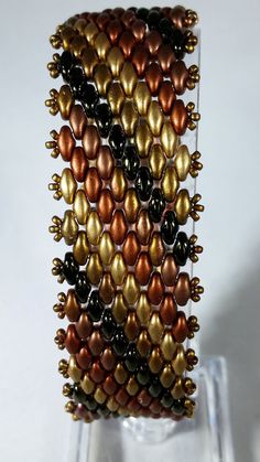 a stack of multicolored beads sitting on top of a glass stand