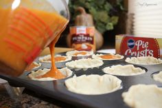 an orange liquid being poured over mini pies