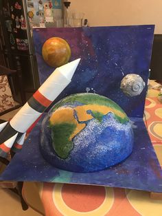 a cake made to look like the earth and rockets