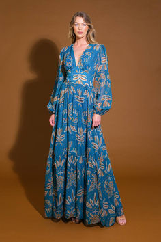 A printed woven maxi dress featuring V neckline, waist yoke, long sleeve, ruffled hemline and smocked back waistband Details: Self : 99% Polyester 1% MetallicLining: 100% Polyester Size & Fit - Model is 5`8" And Wearing Size Small- Measurements Taken From Size Small- Approx. Length: 60" Long Sleeve Floral Print Maxi Dress, Billowy Long Sleeve Floral Maxi Dress, Billowy Maxi Dress With Smocked Back, Bohemian Maxi Dress With Smocked Bodice For Casual Wear, Bohemian Flowy Maxi Dress With Smocked Cuffs, Flowy Bohemian Maxi Dress With Smocked Cuffs, Chic Maxi Dress With Smocked Cuffs, Blue Flowy Dress With Elastic Sleeves, Blue Long Sleeve Dress With Elastic Sleeves