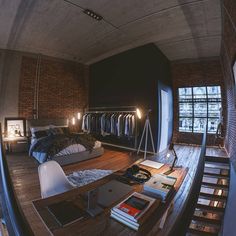 a bed room with a neatly made bed and a spiral staircase leading up to the second floor