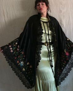 "Beautiful antique Victorian era black satin shawl with silk floral embroidery. Yellow tissue silk lining, two large braided tassel closures at the neckline, and a hook and eye closure below the bust. Black scalloped lace trim. The embroidery on this shawl is unreal and the colors are still extremely vibrant. There are even a few specs of pollen floating around! Measures 90\" x 46\". Condition: Great antique condition. Some fraying/snagging on embroidery, some lightened areas to black satin, and Luxury Black Embroidered Shawl, Elegant Luxury Shawl With Intricate Embroidery, Black Embroidered Silk Shawl, Black Silk Shawl With Traditional Drape, Black Silk Shawl Traditional Drape, Black Bohemian Shawl For Spring, Black Bohemian Shawl With Embroidered Border, Bohemian Black Shawl With Embroidered Border, Black Embroidered Shawl For Festivals