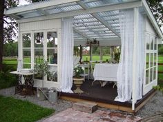 a white gazebo sitting on top of a lush green field