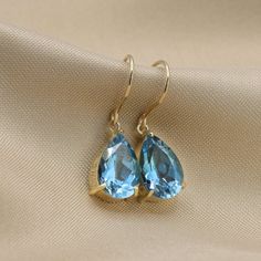 Beautifully matched, these dangling earrings feature two pear shaped London blue topaz gemstone set in 14k gold.Three-prong settings hanging from an elegant French hook. Each stone weighs roughly 2.5 carats, for a total weight of 5.00 carat minimum.- Made to Order, perfectly finished, Fast shipping fully insured and trackable online.- Gemstone information: Two 12x8 mm pear cut, London blue topaz 5.02 ctw- Solid Gold French hook for quick and easy removal.- Arrives gift ready with a certificate o Pear-shaped Blue Topaz Jewelry As A Gift, Pear Shaped Blue Topaz Jewelry Gift, Pear Shaped Blue Topaz Jewelry For Gifts, Pear-shaped Blue Topaz Jewelry For Gifts, Elegant Blue Topaz Teardrop Earrings, Elegant Teardrop Blue Topaz Earrings, Drop Topaz Jewelry For Anniversary, Blue Topaz Teardrop Earrings For Wedding, Blue Topaz Teardrop Birthstone Earrings