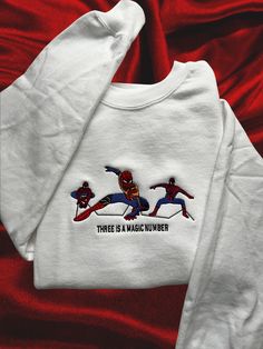 two spider - man sweatshirts with the words three is a magic number on them