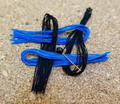 two blue and black cords laying on the ground