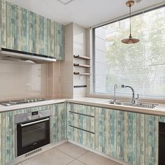 an empty kitchen with blue and green wallpaper on the walls, stove top oven and dishwasher