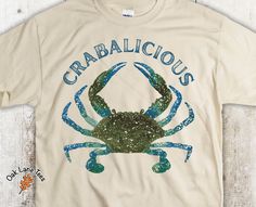 Crabalicious Unisex T-shirt   <------------------------------------> A distressed image. Super soft Gildan tee. You've now found the staple t-shirt of your wardrobe. So Comfortable. Feels great.  Features: Product Information 5.3 oz, 100% pre-shrunk cotton Regular fit S - 3XL  Please look at our Size Chart to order the correct size shirt. Want a loose fit? Go up one size.  Choice of Colors. See image and choose your color choice from dropdown list. Please note that purchasing this listing indica Crab T Shirts, Crab Shirt, Crab Boil, Blue Crab, Beach Shirt, Unisex Tshirt, Beach Shirts, Feeling Great, Crab