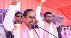 the man is giving a speech in front of other men at a podium with their hands up