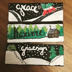 three painted wooden signs with houses and trees on them that say peace, kaurine, graesy