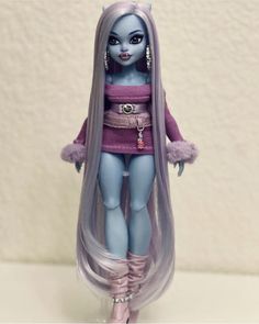 a doll with long purple hair and blue eyes