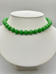 Green Jade Jadeite Bead Necklace.  This hand knotted necklace features 32 Green Jade Jadeite Beads Round Polished Grade AAA 11.9 to 12.4mm.  I hand knotted these with green silk thread and finished them with a 925 Silver Fold Over Magnetic Clasp.  The necklace measures 18 inches in length.  Please keep in mind that large beads take up space on the neck and they will fit tighter than an 18 inch chain.  The Beads are Genuine and Natural in color, no treatments.  The necklace pictured is the one you will receive.   It will arrive in a nice presentation box with a Certificate of Authenticity.   Please visit our Shop for more Pearls and Gemstone Jewelry. Classic Green Gemstone Beads Necklace, Classic Jade Necklaces With Round Beads, Classic Jade Necklace With Round Beads, Classic Green Jewelry With 8mm Beads, Elegant Green Hand-strung Necklace, Classic Green Single Strand Necklace, Formal Green Single Strand Beaded Necklace, Green Beaded Necklaces With 8mm Round Beads, Round Green Beaded Necklaces With 8mm Beads