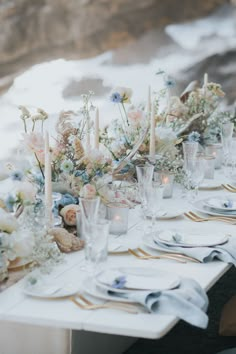 the table is set with flowers and candles