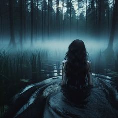 a woman sitting in the middle of a body of water surrounded by tall grass and trees