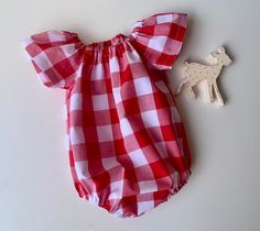 Super pretty red cotton gingham seaside playsuit .  This pretty playsuit has cool sun safe  sleeves . It has snaps at the crotch for easy  nappy changes . It is cool and comfy as well as being stylish.  Perfect matched with some red or gold accessories for the festive season.  Available to order in sizes newborn 0-3 months 3-6 months 6-12,12-18 and 18-24 months . Just select size needed at check out.  Please allow approx 5-7 days for your romper to be handmade.  Thanks for looking.  'Like' Simpl Plaid Cotton Bubble Romper For Summer, Summer Plaid Cotton Bubble Romper, Summer Cotton Plaid Bubble Romper, Cute Red Cotton Jumpsuit And Rompers, Cute Red Cotton Jumpsuit/romper, Playful Red Jumpsuits And Rompers For Summer, Red Cotton Jumpsuit For Playtime, Playful Red Summer Jumpsuit, Cute Summer Plaid Bubble Romper