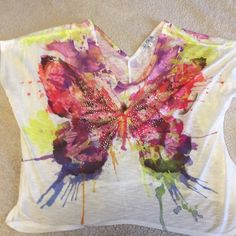 a white t - shirt with a butterfly painted on it